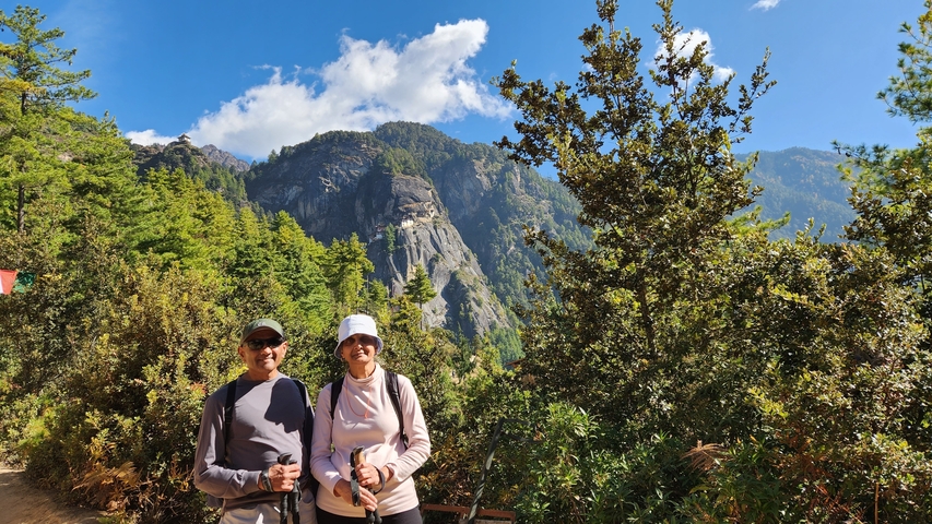       Two hikers posing in front of a lush mountain.
  