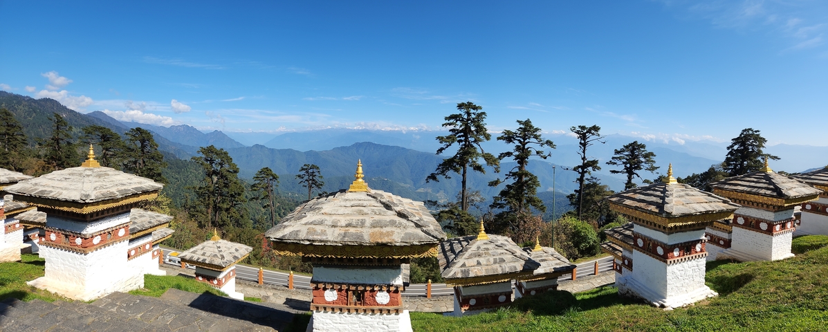       Panoramic view of stupas and mountains.
  