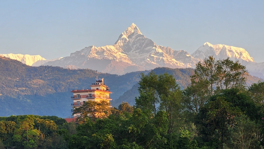       A building with mountain peaks in the background.
  