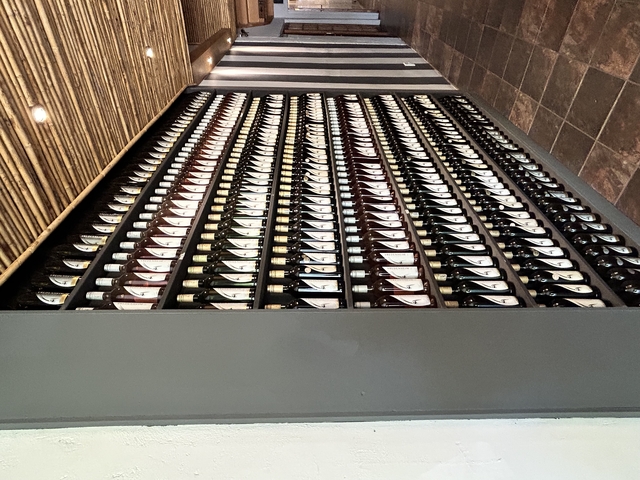       Rows of wine bottles neatly organized on a rack.
  