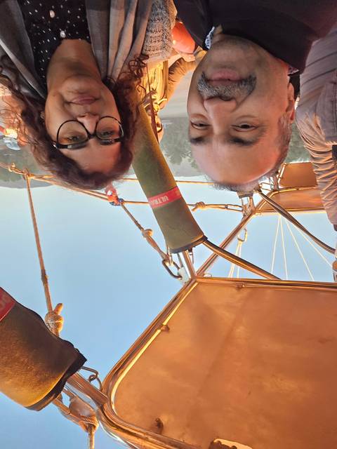Couple in a hot air balloon with sunset views.