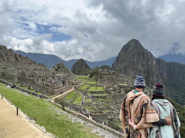 Couple looking at the ancient ruins of Machu Picchu.