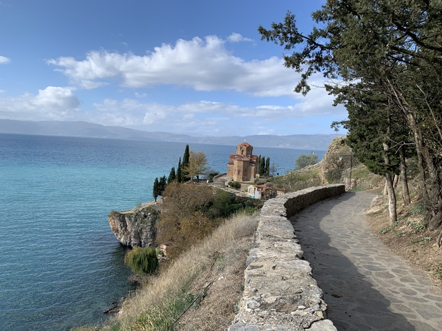       Scenic view of a church on a cliff by the sea with a stone pathway.
  