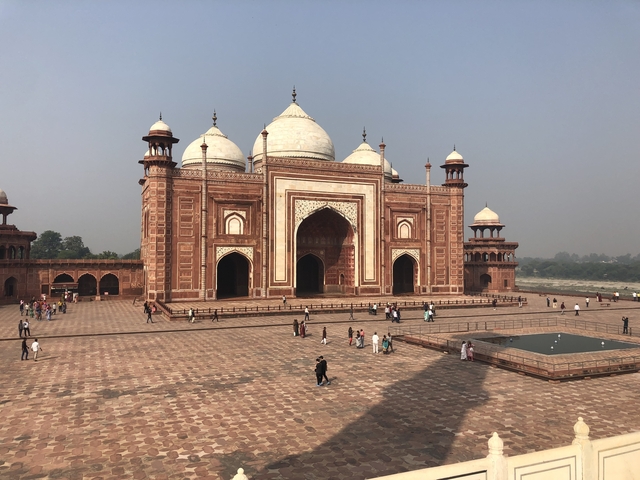       Tourists at a large historic mosque courtyard.
  