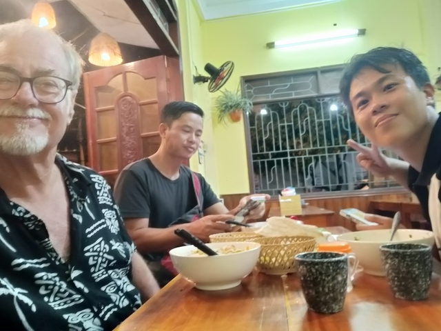       Three people enjoying a meal inside a restaurant.
  