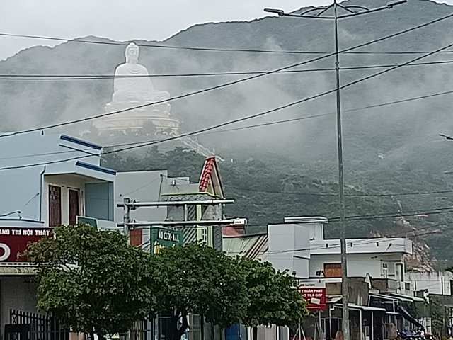       Large statue visible from a misty, urban landscape.
  