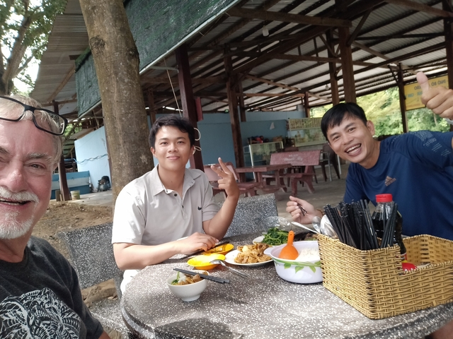       Two men enjoying a meal with food on the table.
  