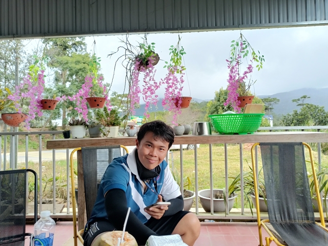       Person posing with flower decorations in an outdoor setting.
  