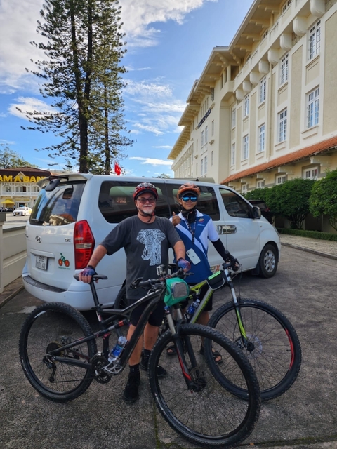       Cyclists posing with a van in the background.
  