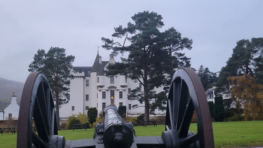 Cannon pointing towards a large white house.