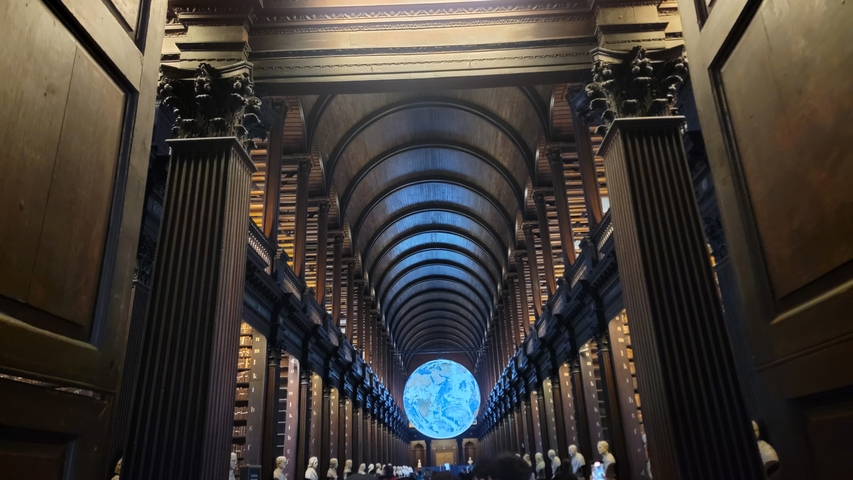       Interior of a grand library with a globe on display.
  