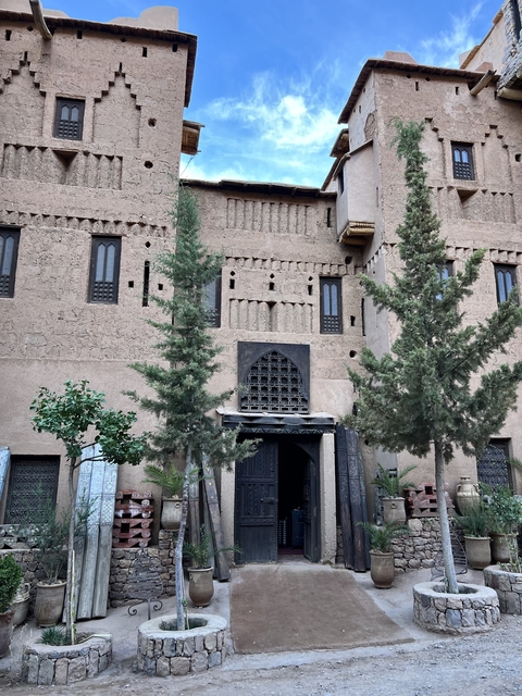 Old stone building with two trees in front.