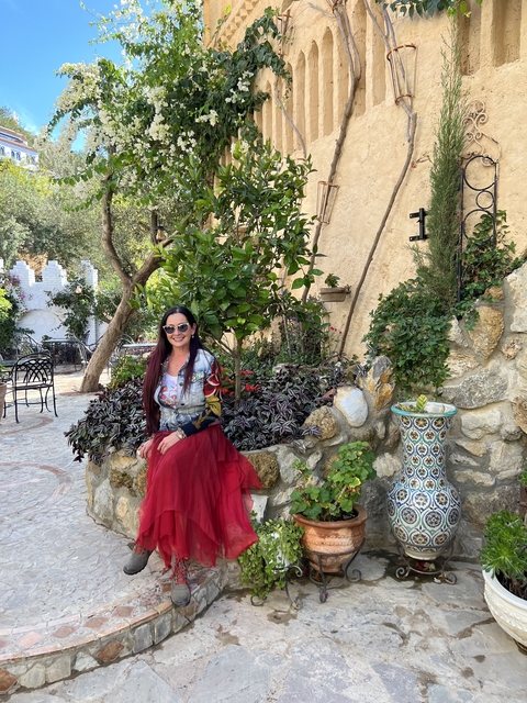       Woman sitting in a garden area with stone pathways.
  