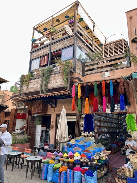      Colorful textiles hanging outside a building in a market area.
  