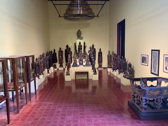 Room filled with ornate sculptures and statues, displayed in a museum setting.