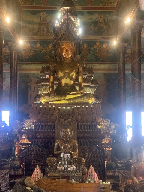       Golden statue of a seated figure, possibly within a temple.
  
