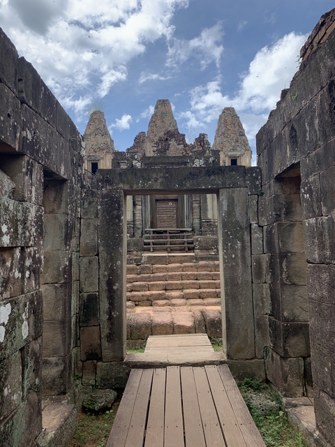 A view through a stone doorway towards ancient temple ruins.