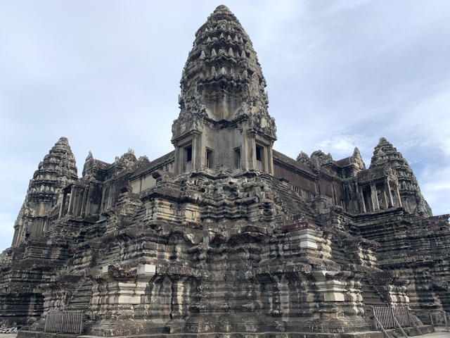       The iconic towers of Angkor Wat against a cloudy sky.
  