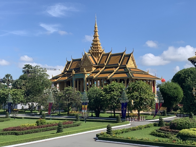       A beautiful temple with golden detailing and lush greenery.
  