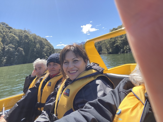 People on a jet boat ride with scenic backdrop.