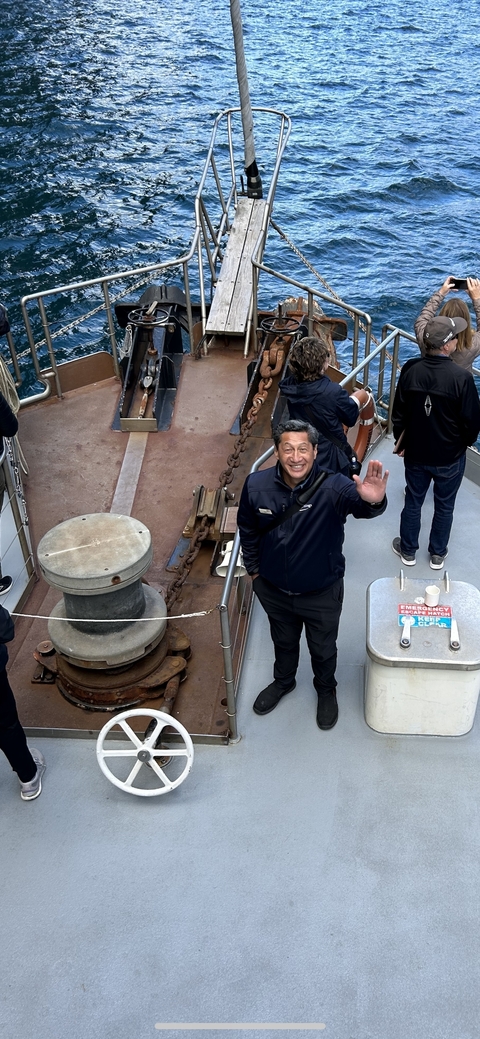Person waving on a ferry deck.