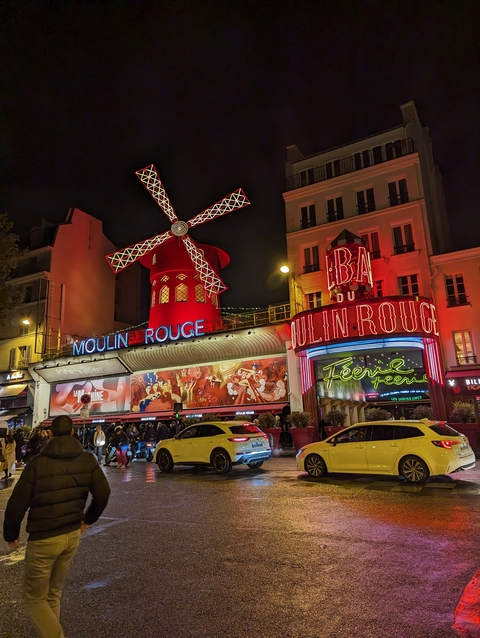 Exterior view of the iconic Moulin Rouge at night.