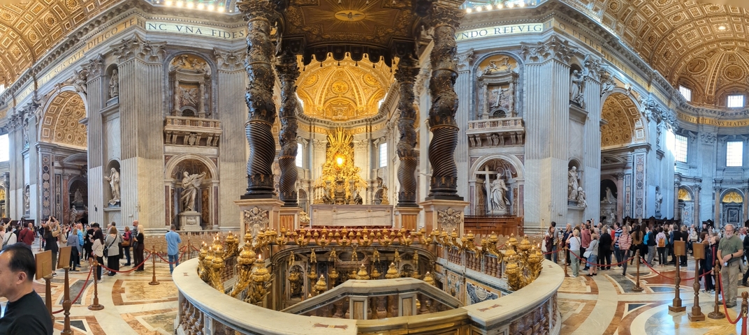 Interior of St. Peter's Basilica with ornate detailing and visitors.