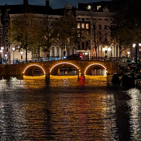 Elegant bridge over a canal with lights reflecting.