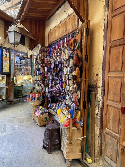       Colorful display of traditional Moroccan slippers in a market.
  