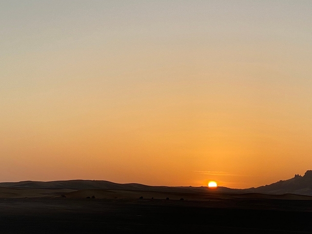 Sunset over sand dunes in the desert.