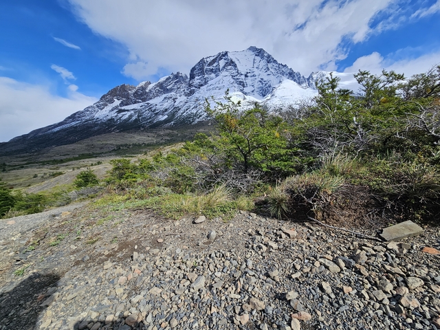       Rocky mountain with snow and green foliage.
  