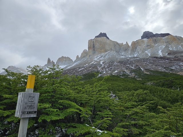 Mountain peaks with some snow, surrounded by lush greenery.