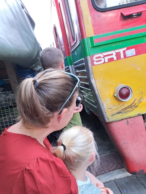 People close to a train in a crowded area.