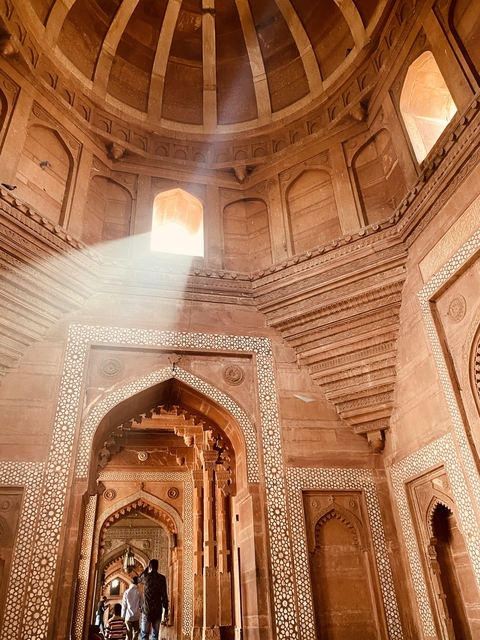 Inside an intricately designed dome, sunlight streaming through an opening.