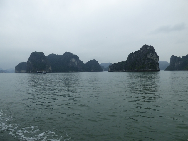 Boats in a bay surrounded by tall rock formations.