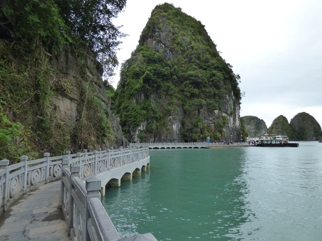       Rocky shoreline with a stone walkway along a bay.
  