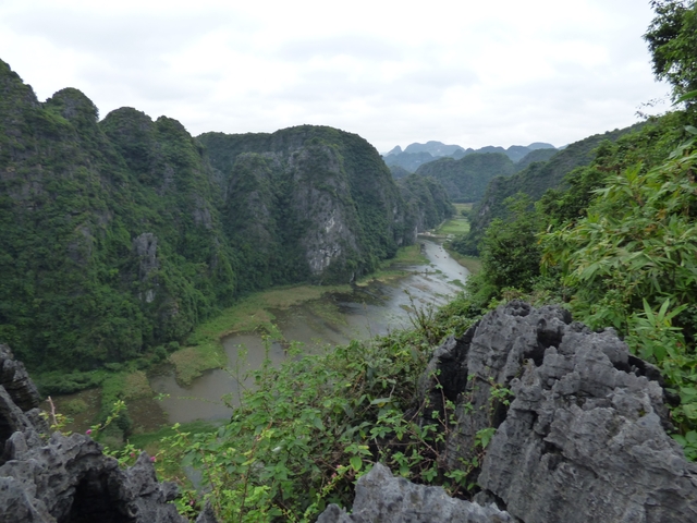       Scenic landscape with lush green mountains and a river.
  