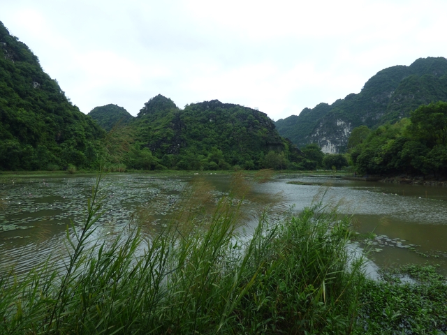 Calm lake with green mountains in the distance.