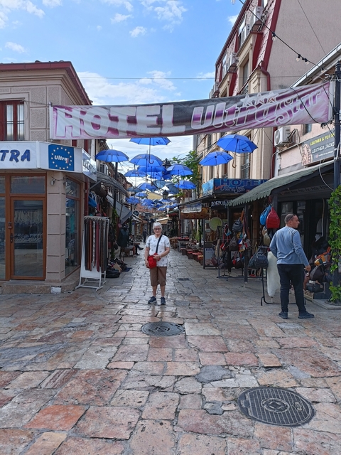 Street market with umbrellas and people walking.
