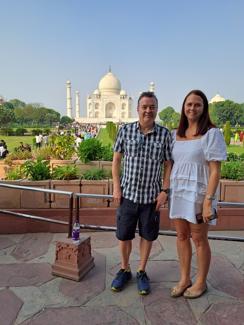       A couple posing in front of the iconic Taj Mahal.
  