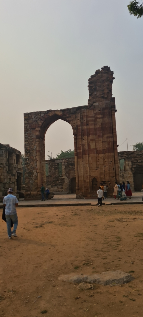 Entrance gate of a historic site with people around.