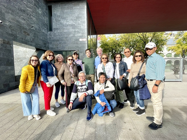 A group of tourists standing outdoors posing for a photo.