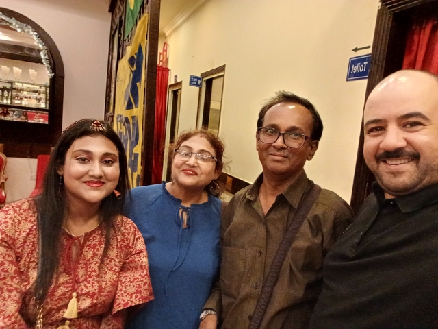 A group of four people taking a selfie indoors.