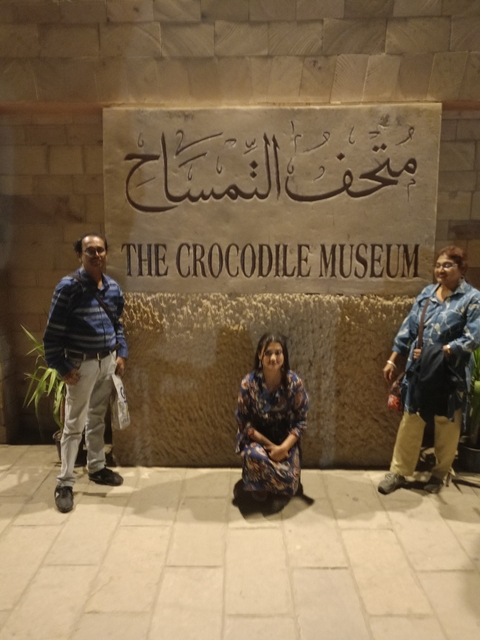 A family posing in front of 'The Crocodile Museum' sign.