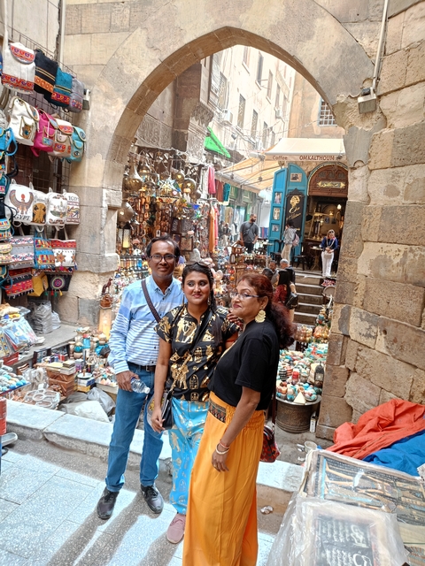 A group of people standing in a bustling market.