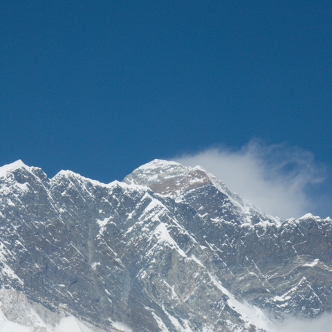 Snow-covered mountain peaks against a blue sky.