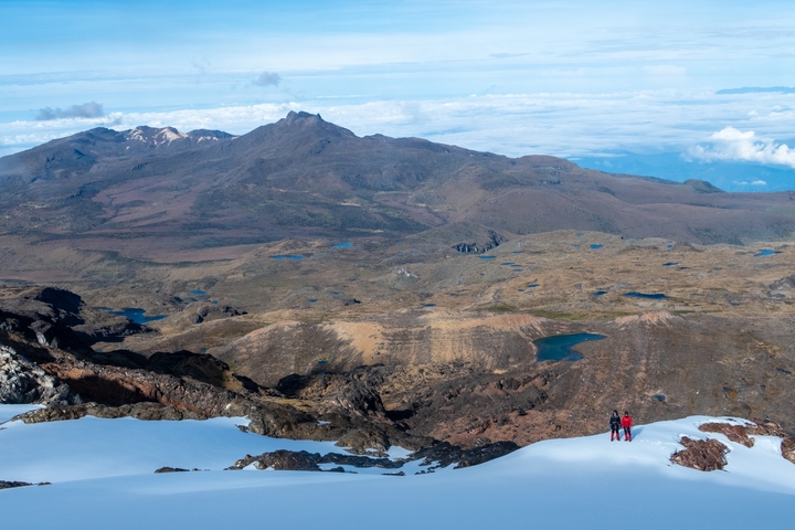       Hikers in a snow-capped mountain landscape.
  