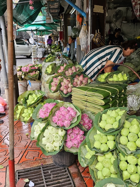 Fresh flowers and leaves on sale at a market stall.