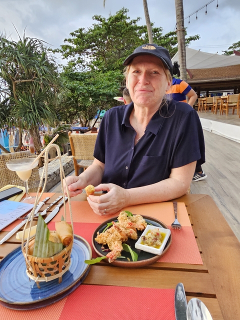       Woman dining at an outdoor cafe with a platter of food.
  