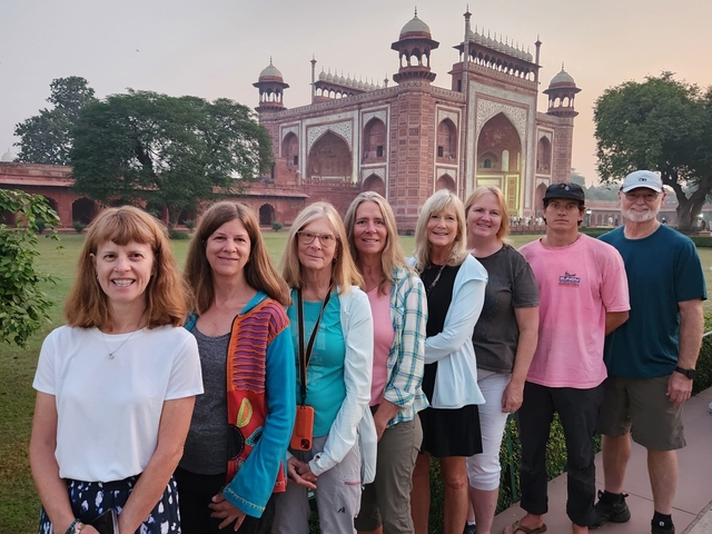       Group of tourists at a historical site with an ornate building.
  